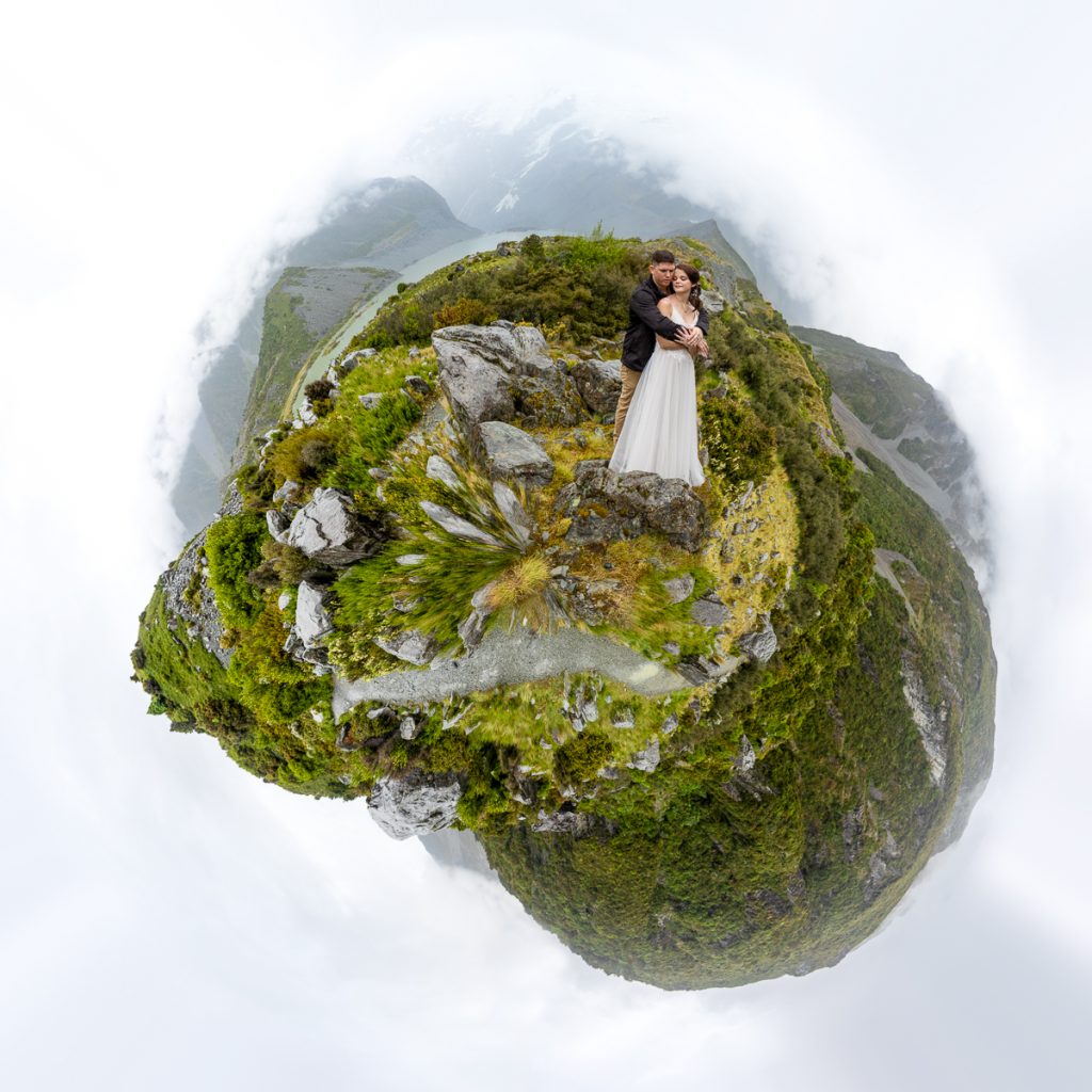 A 360 degree image of the wedding couple in the rain surrounded by mountains in Hooker Valley on South Island of New Zealand.