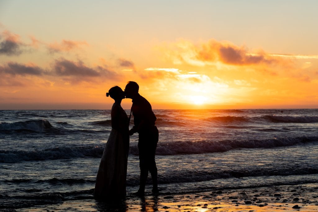 A silhouette of a couple kissing at their unique california elopement.