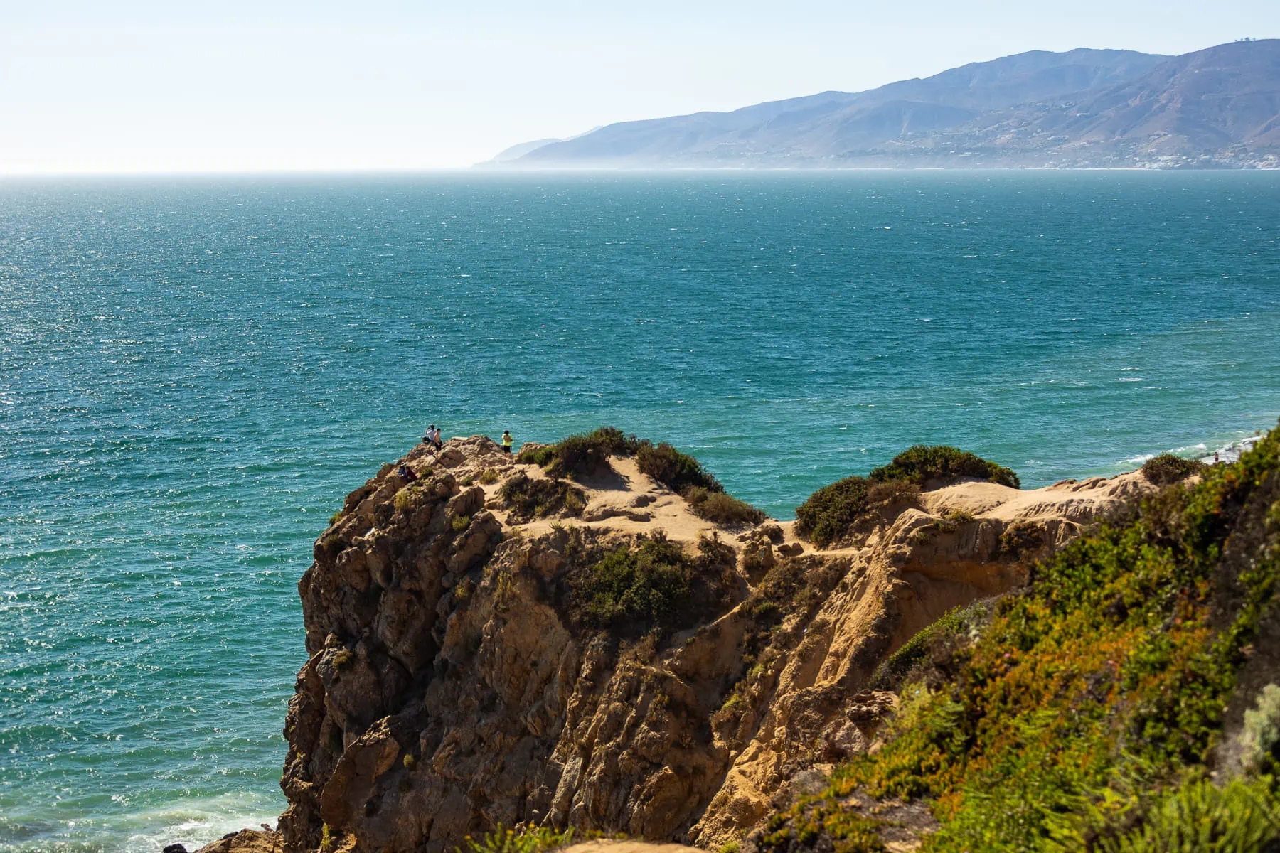 Point Dume elopement location on the southern California coast with sparkling teal water and colorful cliffs.