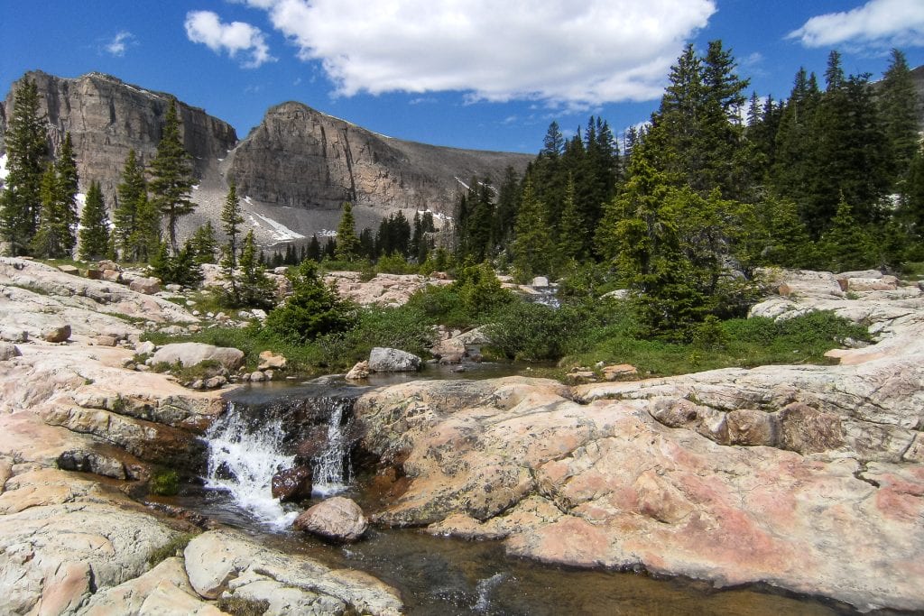 The high peaks of Utah are beautiful in summer. This waterfall and mountains are located in the high Uintas range.