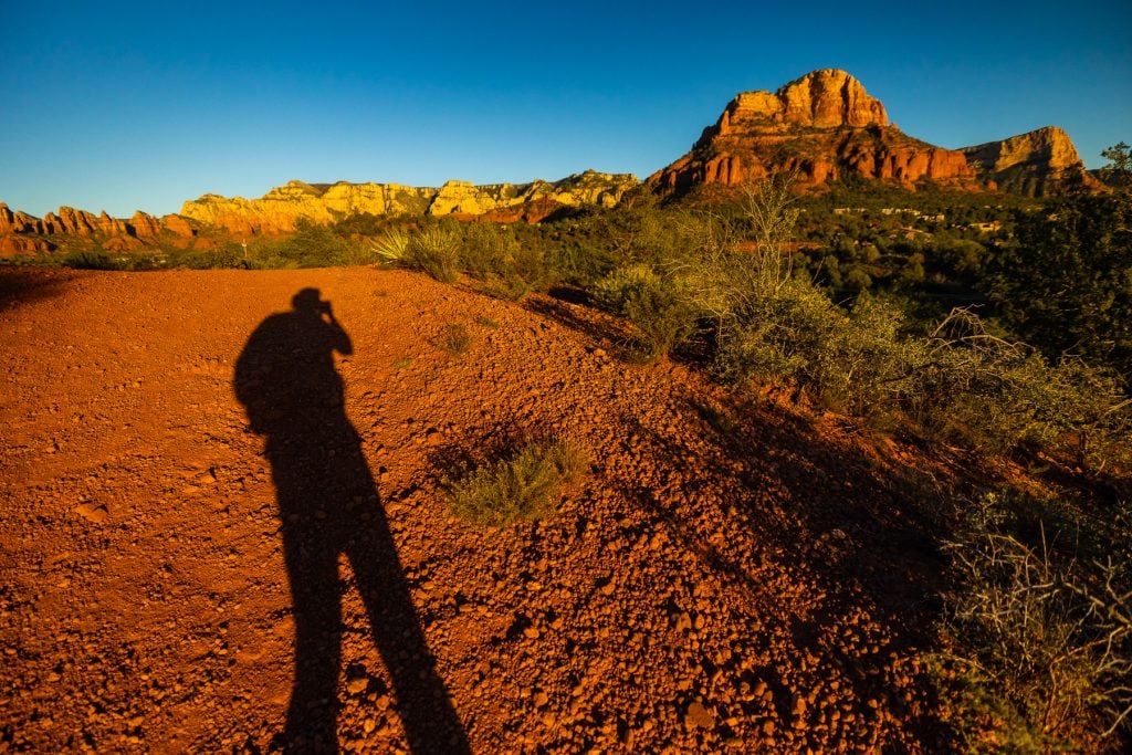 The shadow of Sedona elopement photographer Lucy Schultz in the mountains of the Sedona desert.