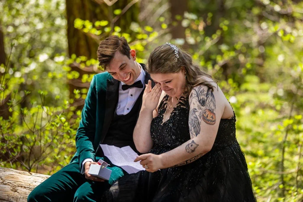 A bride wearing a black dress gets emotional while reading a letter sent by one of her best friends during her yosemite elopement.
