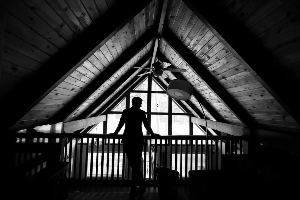 A black and white silhouette of a groom in a cabin in Yosemite National Park.