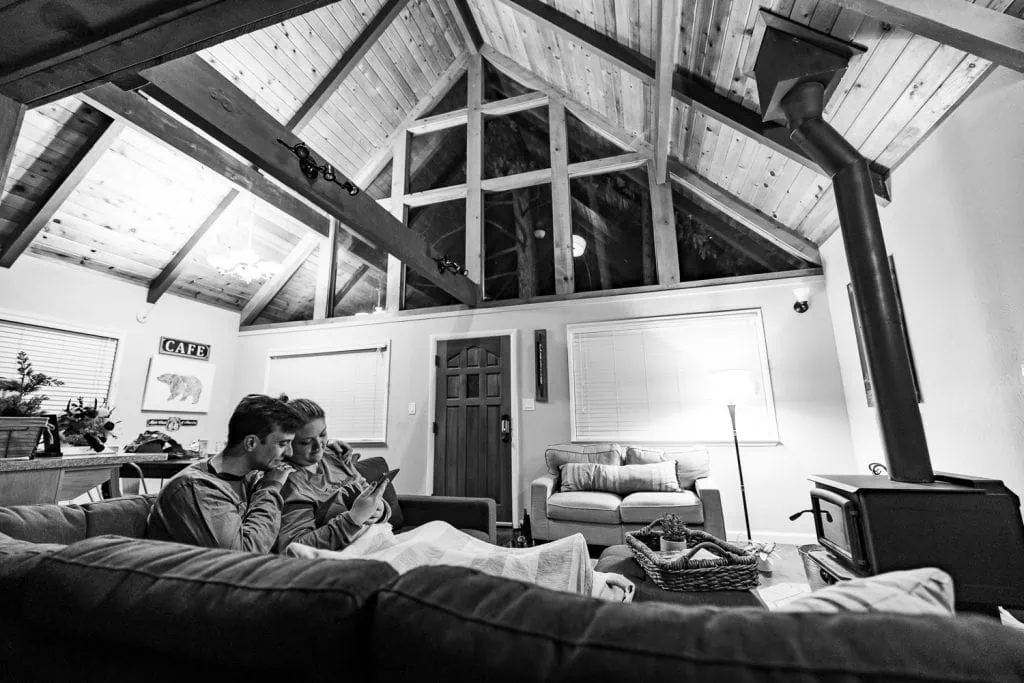 A black and white image of a yosemite elopement couple back in their cabin reading messages that friends had sent.