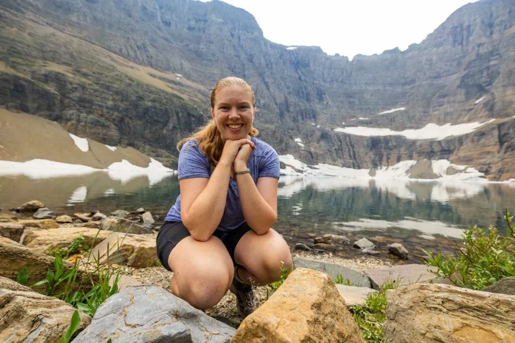Glacier national park elopement photographer Lucy Schultz smiles at the camera while on a hike to Iceberg Lake.