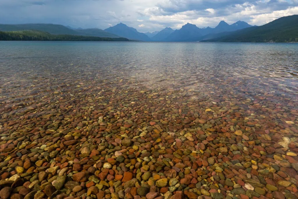The colorful stones of Lake McDonald in Glacier National Park are visible below the lakes surface.