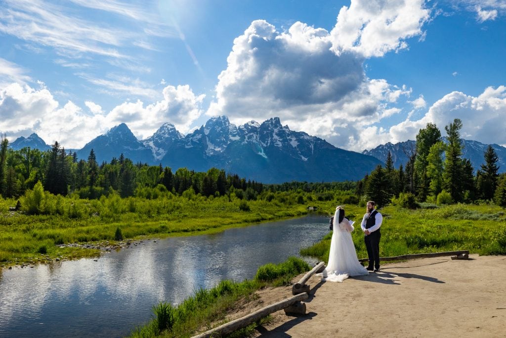 An elopement ceremony at Schwabacher's landing taken in the afternoon in late June. The mountains tower over the river as a couple says their vows.