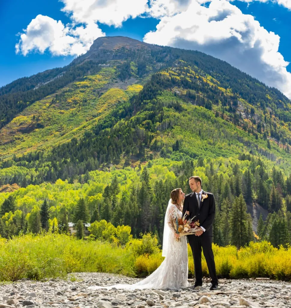 A portrait of an elopement couple under a mountain with blue skies in Marble, Colorado..