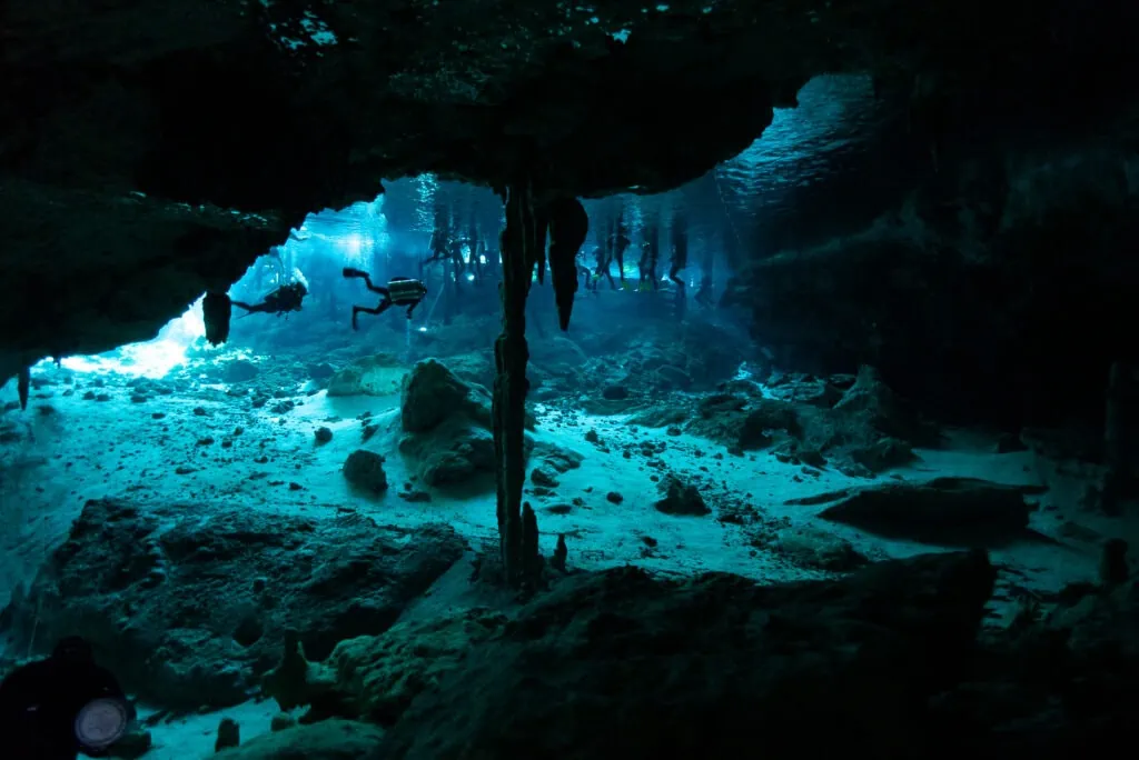 Underwater diving elopement photography Lucy Schultz shows off the beautiful light beams of a Mexican cenote.